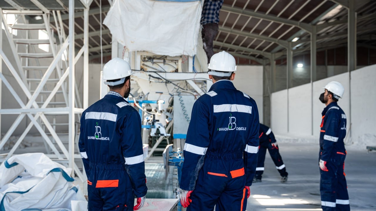 Bahadin Chemicals workers in branded overalls and hard hats at the plant