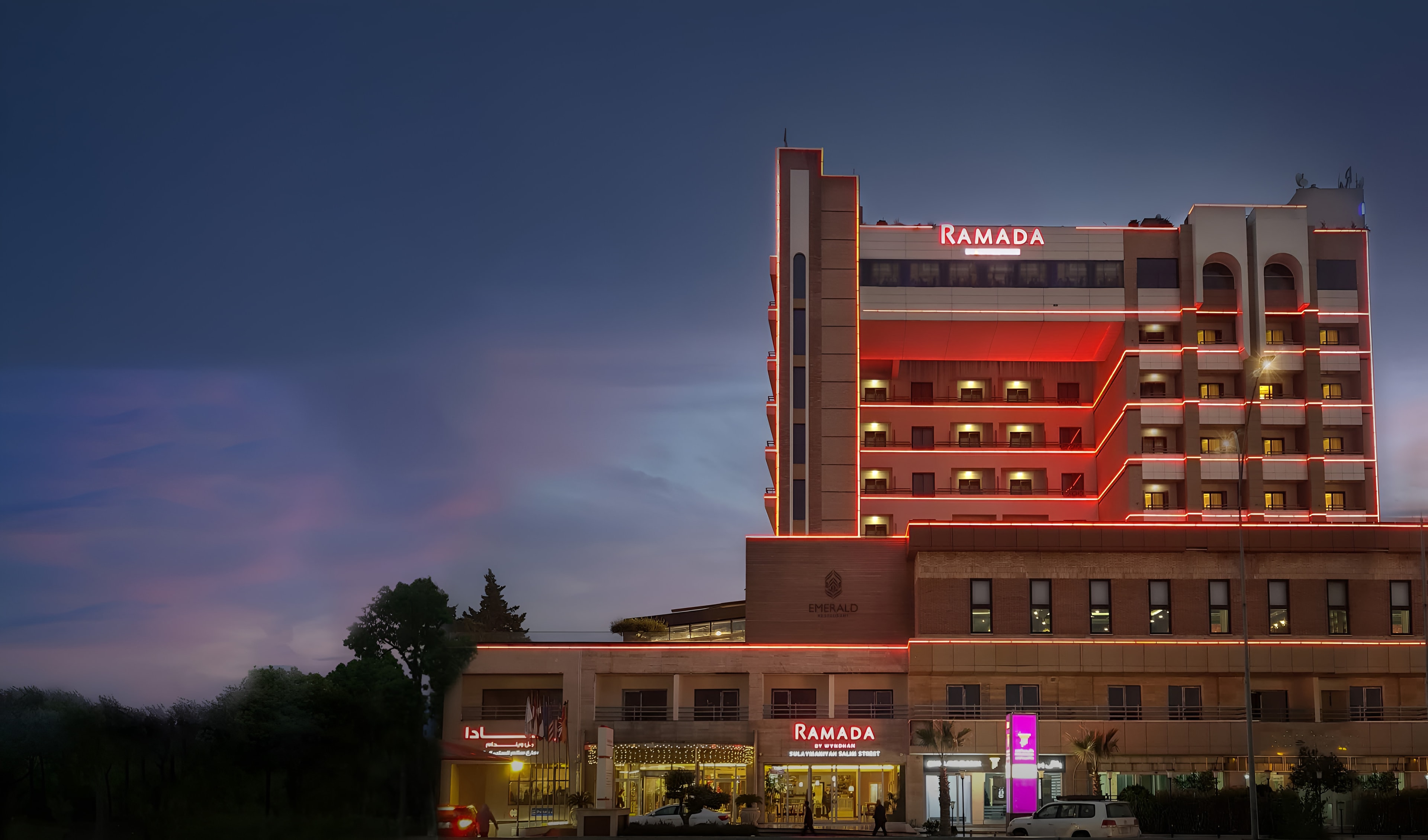 The Ramada hotel lit up at dusk