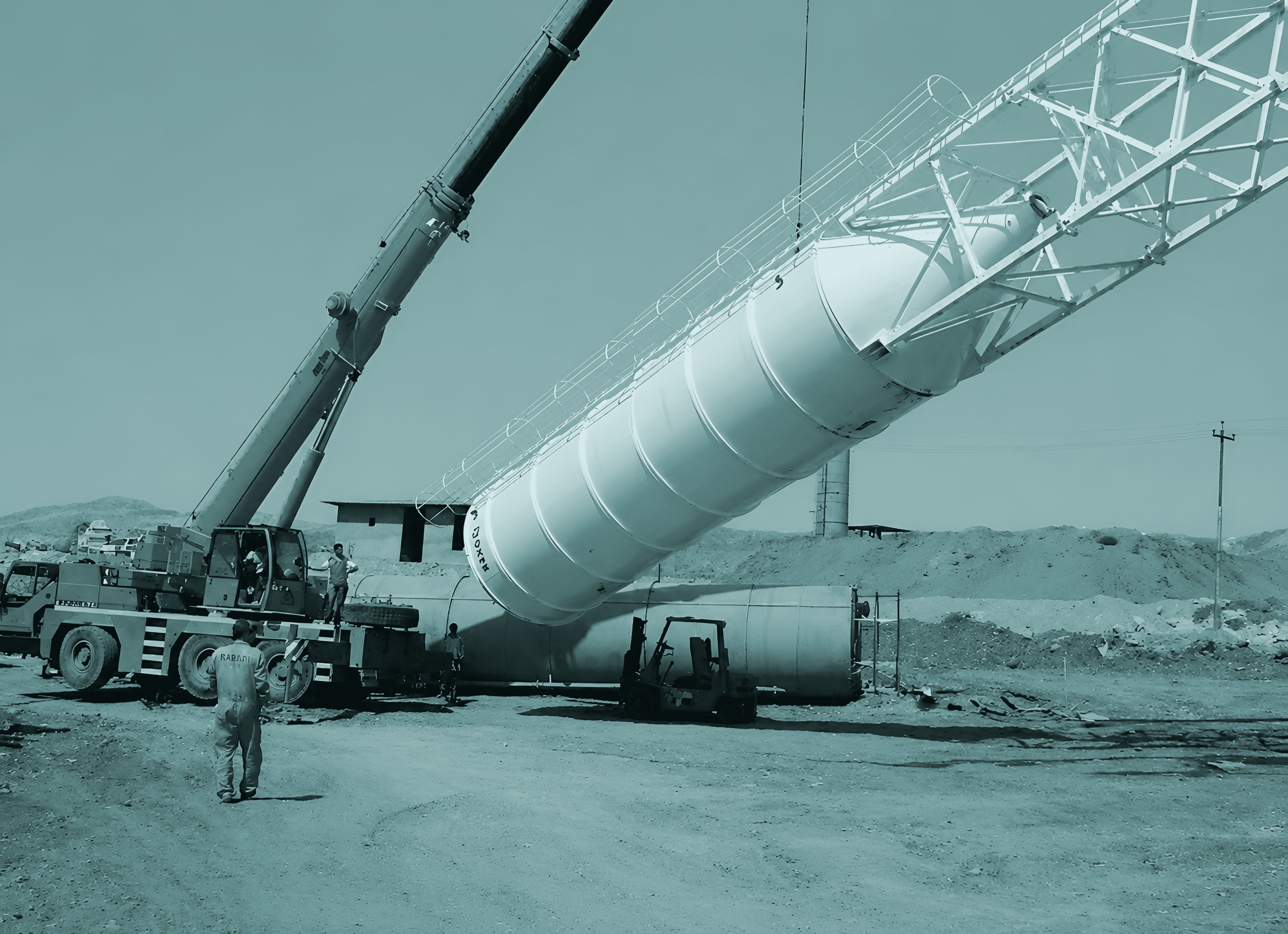 A crane lifting a cement silo into place at the first plant